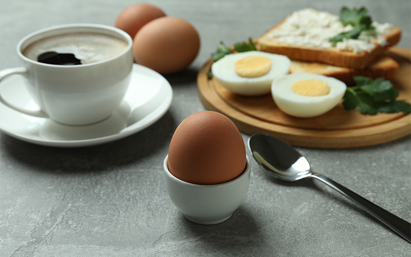 Coffee, soft-boiled egg, and toast, a delicious breakfast combination.