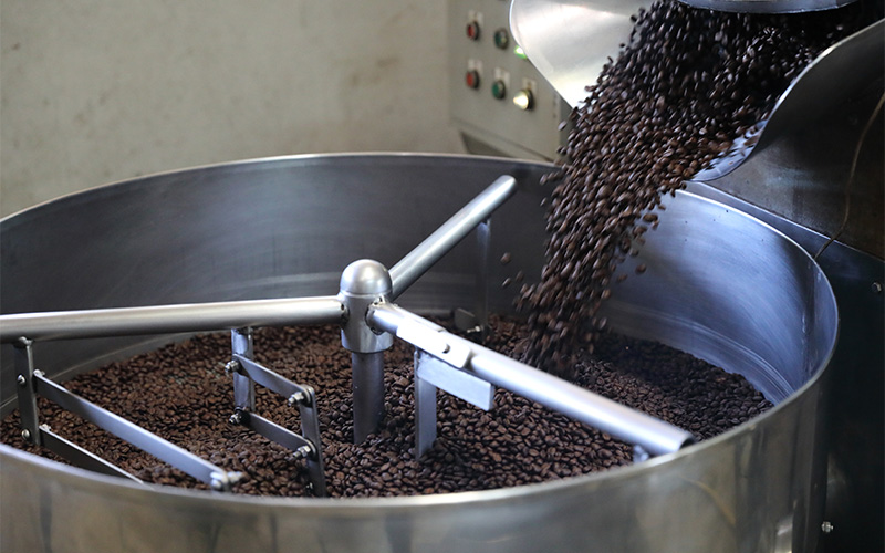 Freshly roasted coffee beans being churned in a cooling drum.